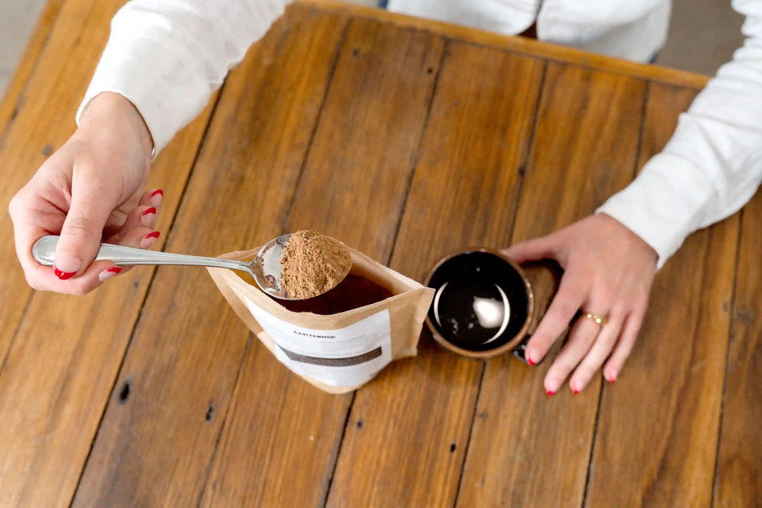 A person scooping Earthrise coffee alternative into an empty cup